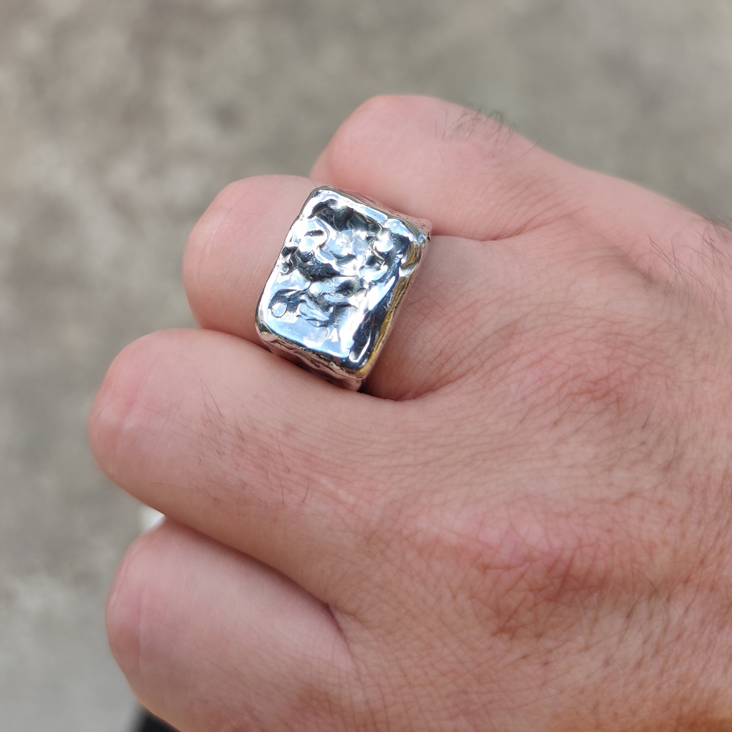 Anello chevalier uomo in argento 925, vista a tre quarti che evidenzia la texture lavorata a mano