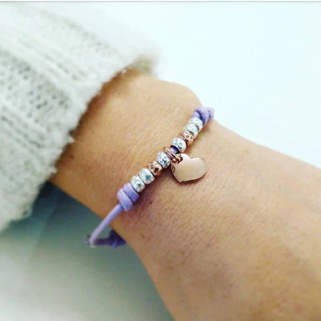 ragazza donna indossa braccialetto cordino cotone cerato con pepite granelli argento 925 simil tipo dodo mariani ciondolo cuore