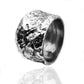 Anello uomo in argento 925 con superficie martellata artigianale, design largo e texture irregolare, su sfondo bianco.