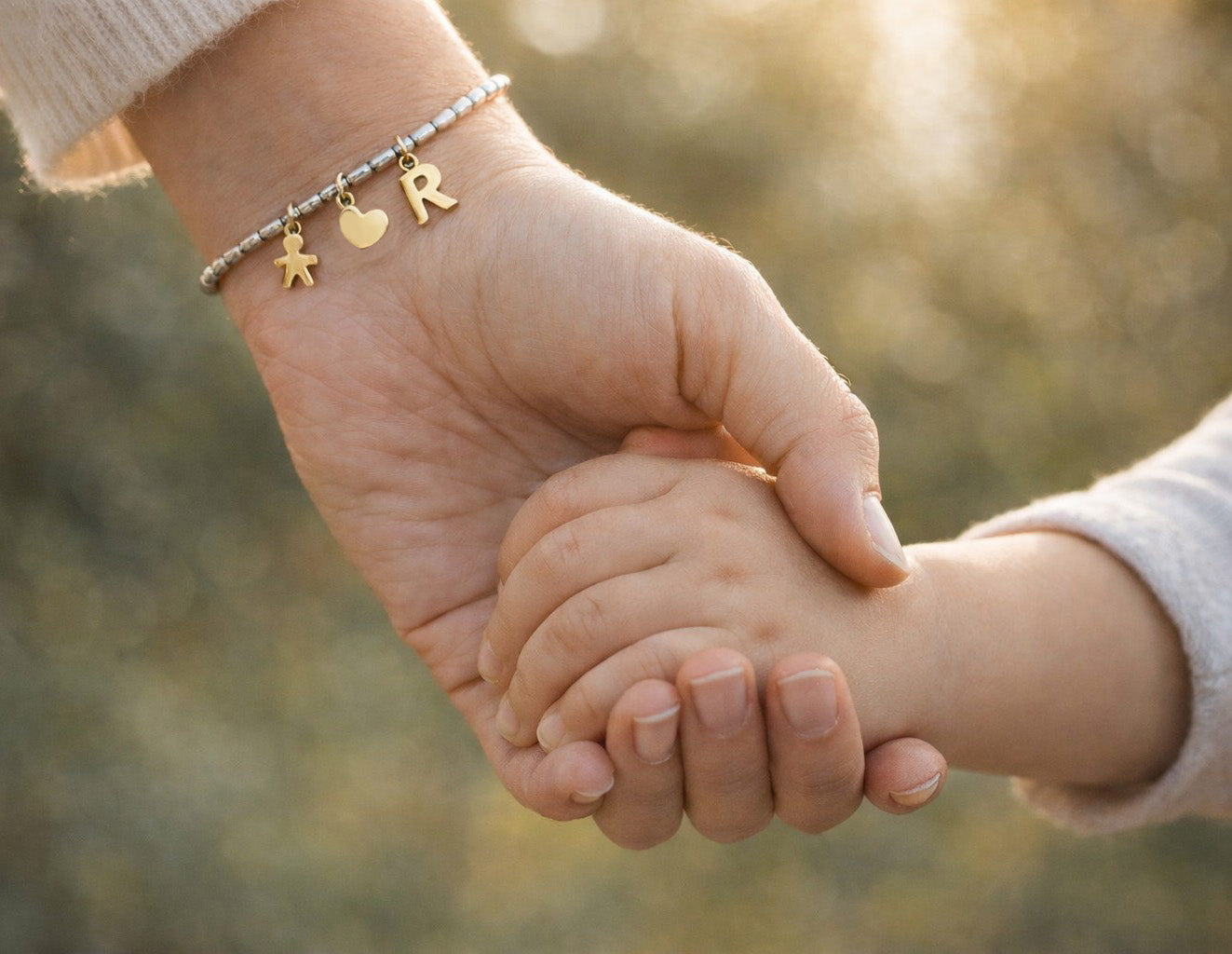Bracciale mamma personalizzato argento 925 indossato, mano che tiene mano di bambino, idea regalo nascita.