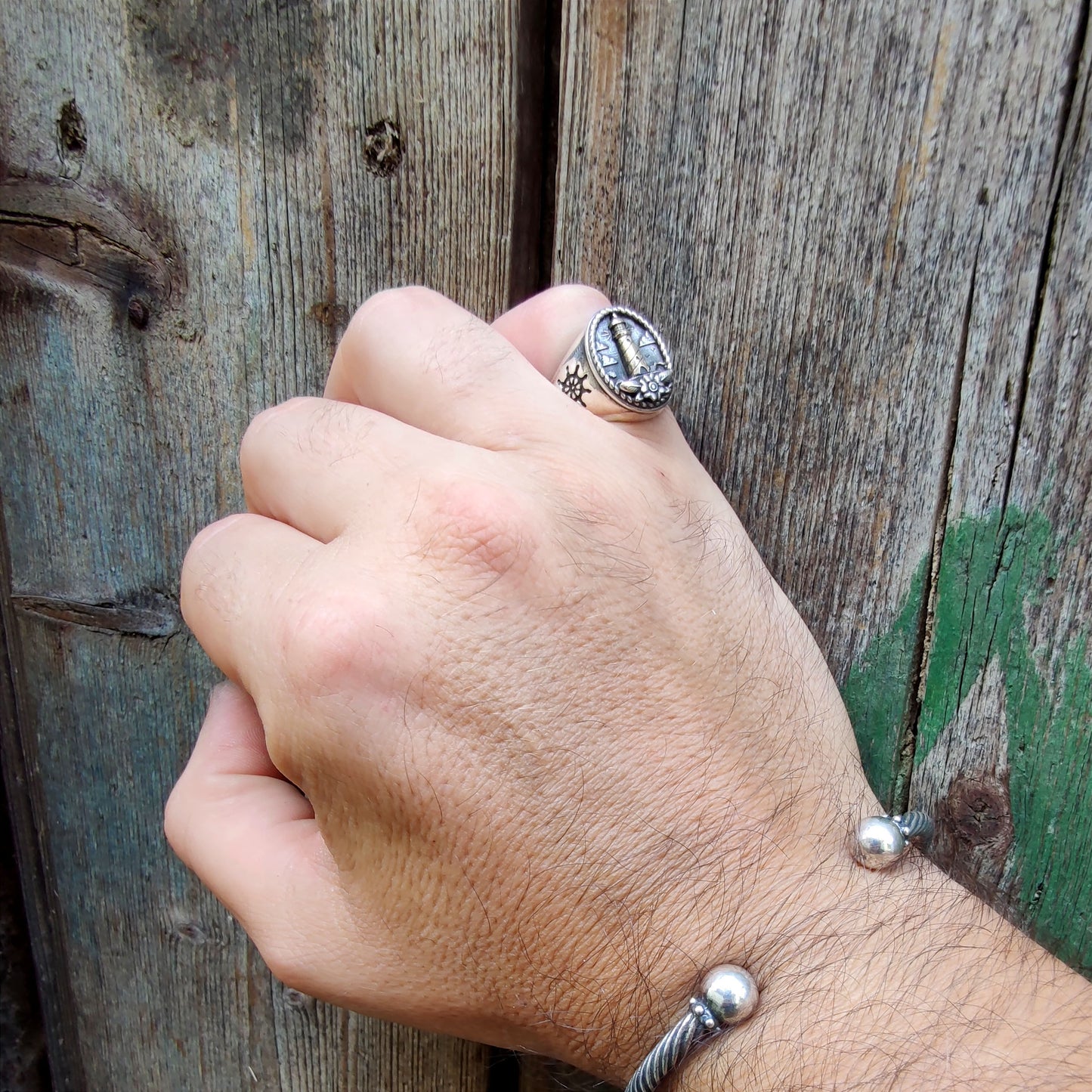 Anello Faro indossato su dito mignolo, luce naturale, look casual