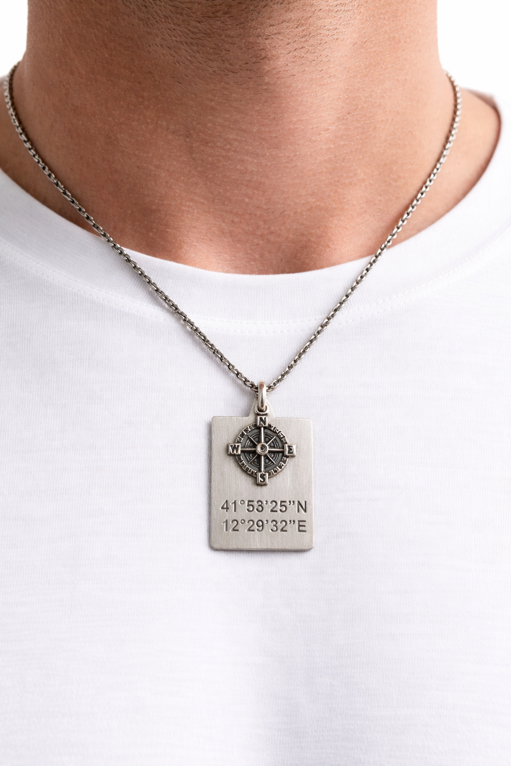 ollana in argento 925 con piastrina coordinate GPS e bussola, indossata da un uomo.