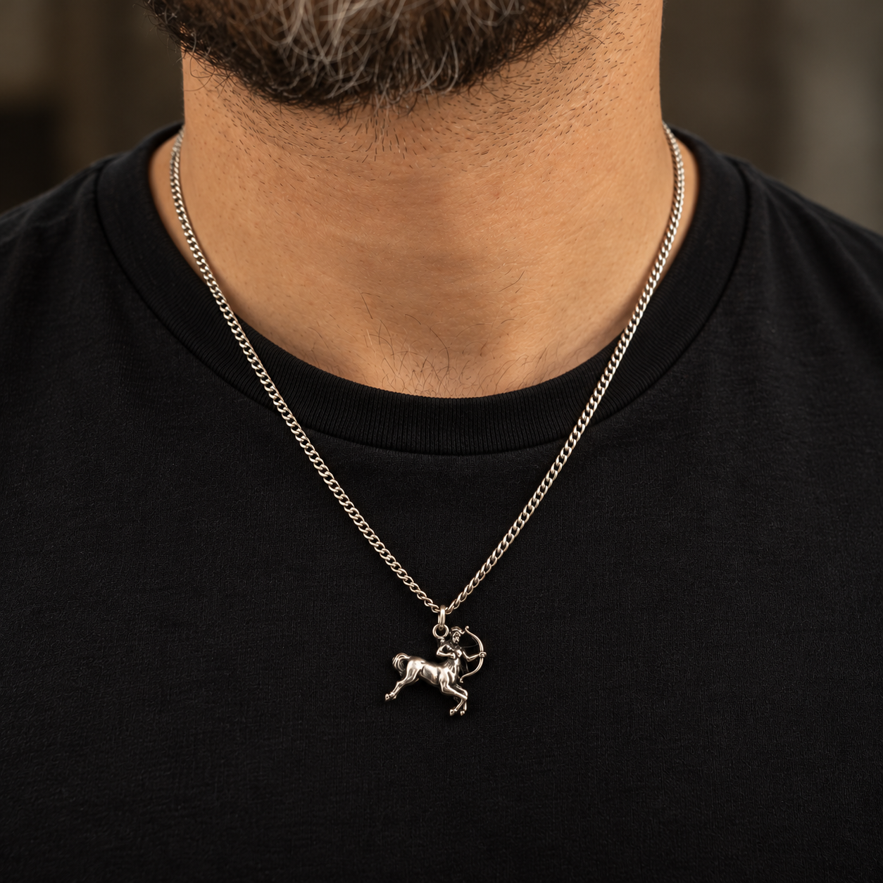 Uomo con collana Sagittario in argento 925 brunito indossata sopra maglietta nera, catena grumetta da 2 mm.