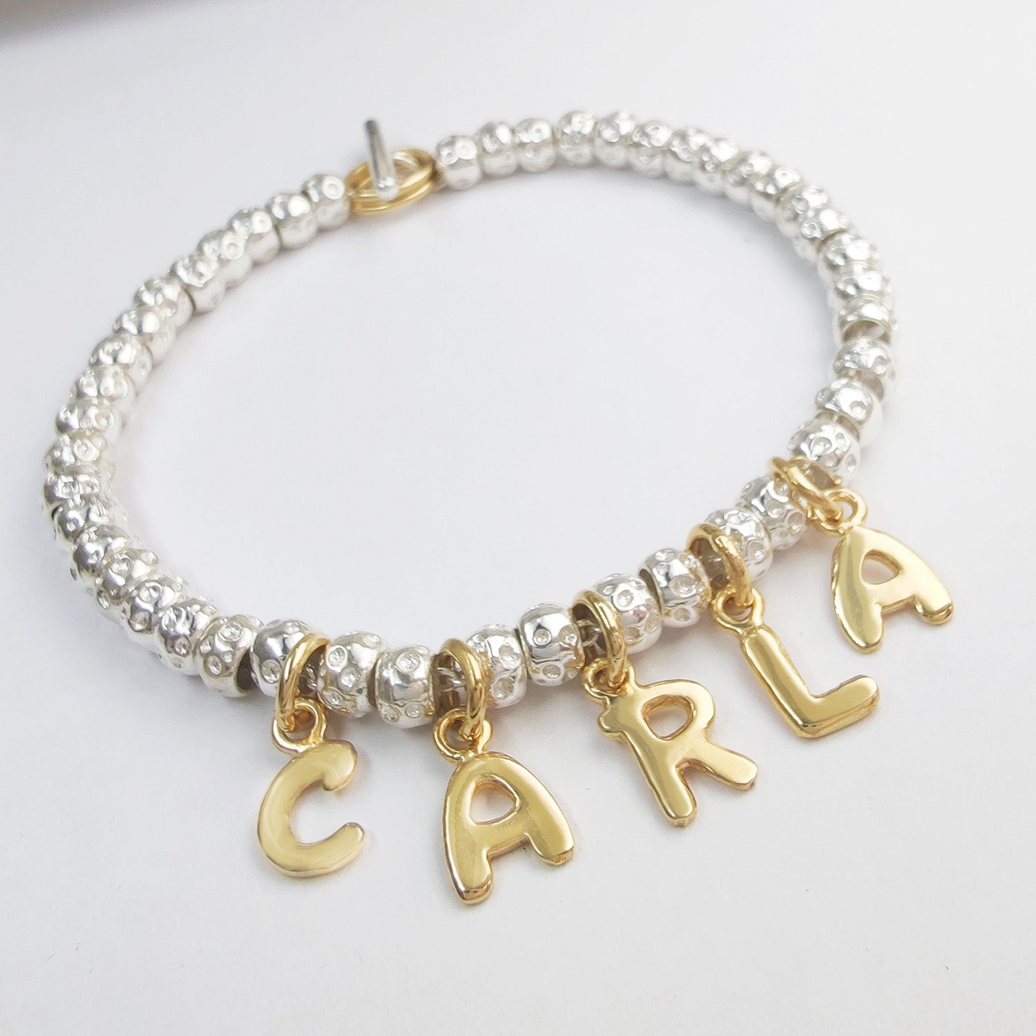 braccialetto con granelli a imitazione simil tipo dodo mariani con ciondoli lettere alfabeto a formare nome figli carla prezzo scontato offerta outlet