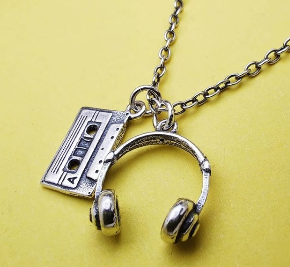 Dettaglio cuffie DJ e musicassetta su collana uomo argento nero antico
