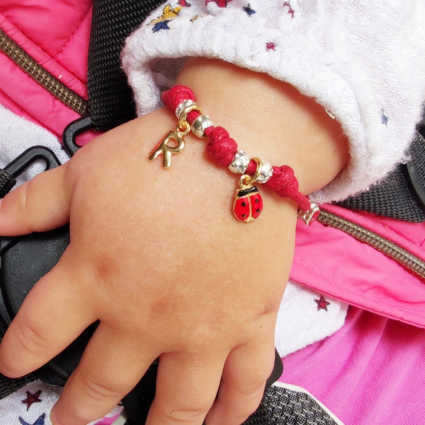 bracciale per bimbo bimba neonato cordino colorato granelli pepite dadini tipo simil imitazione dodo mariani ciondolo iniziale coccinella portafortuna regalo ideale per battesimo nascita primo compleanno vendita online gioielli artgianali